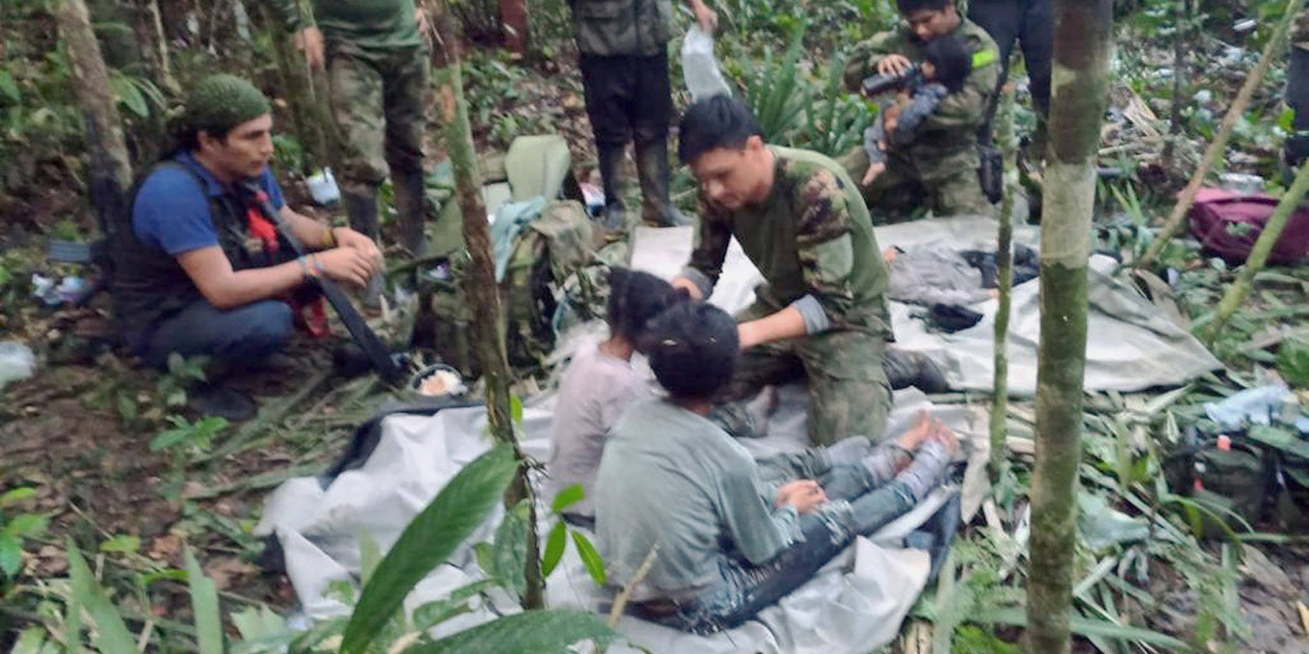 Soldaten und Ureinwohner kümmern sich um die Kinder, die nach 40 Tagen im Dschungel gerettet wurden.