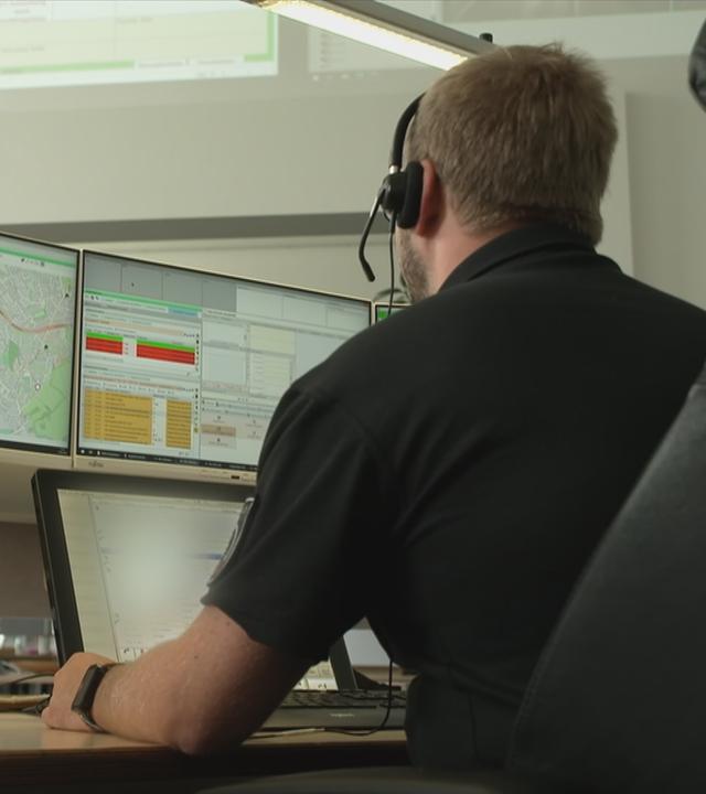 Mitarbeiter in der Rettungsdienstzentrale vor dem Computer
