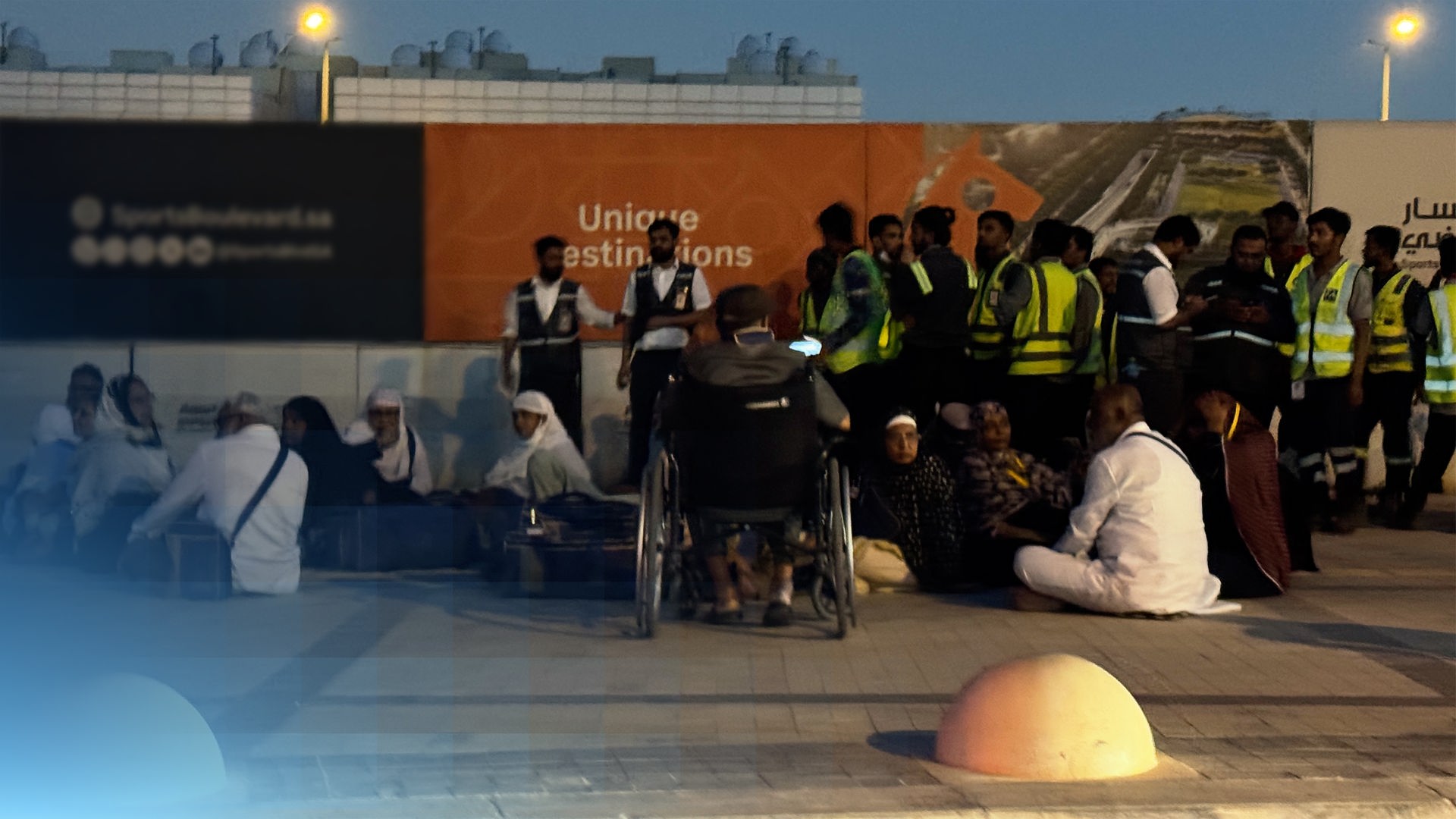 Mehrere Menschen stehen nahe des Flughafens Riad an einer U-Bahnstation.