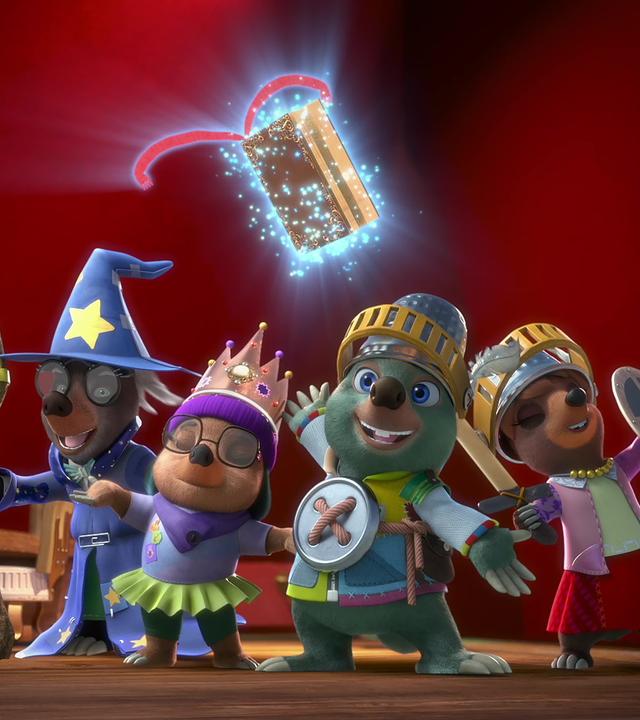 Auf einer Theaterbühne stehen Mischmasch, Dotty, Moley und Mona Lisa. Sie sind in Kostüme passend zu ihrer Rolle gekleidet. Mischmasch als Zauberer, Dotty als Prinzessin, Moley und Mona Lisa als Ritter. Über ihnen schwebt das magische Buch Mauli.