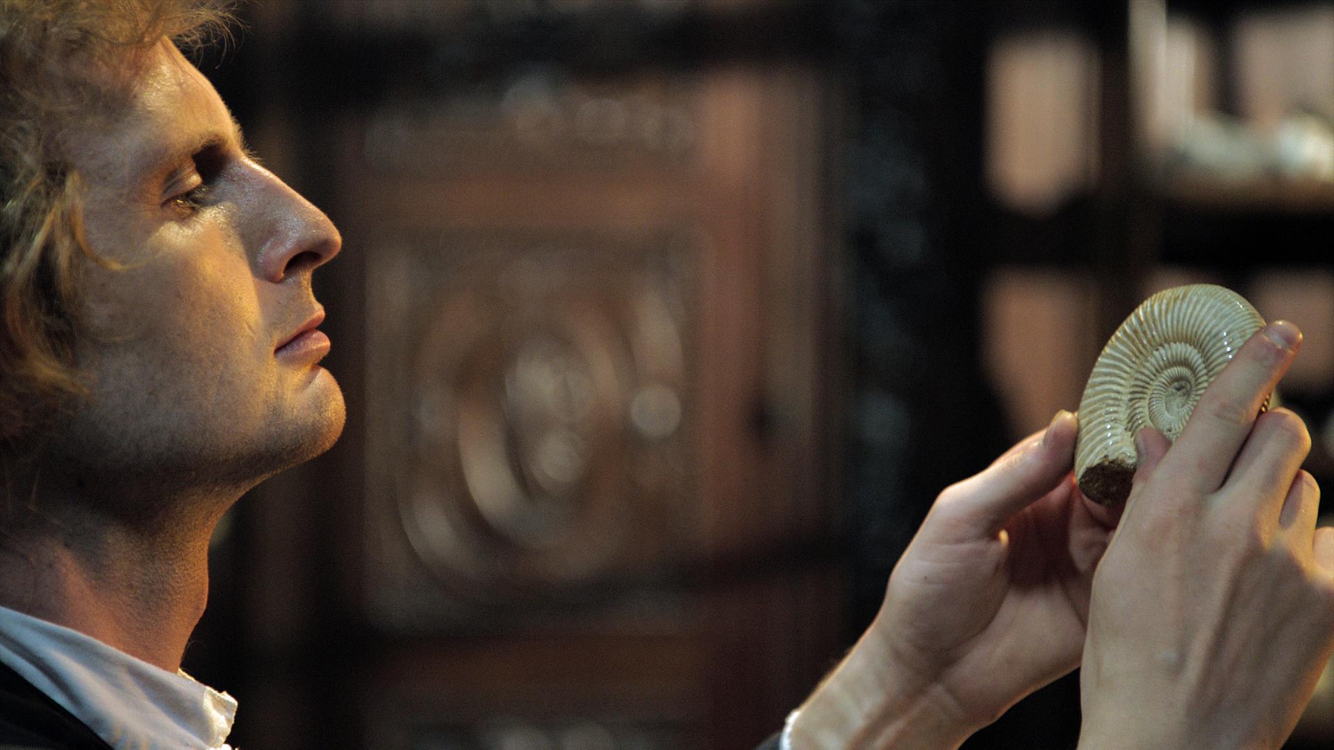 Robert Hooke betrachtet einen Ammoniten (Spielszene)