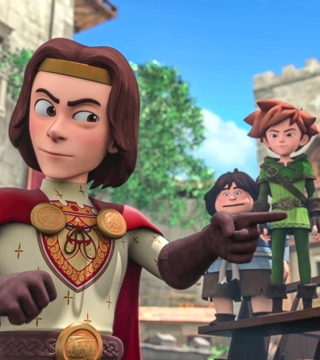 König Richard zeigt mit dem linken Zeigefinger auf etwas. Rechts im Hintergrund stehen Robin und seine Freunde auf einer Tribüne.