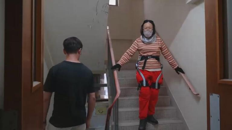 Frau bei Nutzung von Roboter-Anzug zum Treppensteigen in Hongkong.