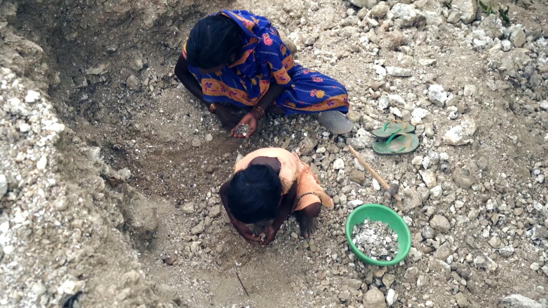 Frau und Kind suchen in einer Mine in Indien nach dem begehrten Rohstoff Mica 