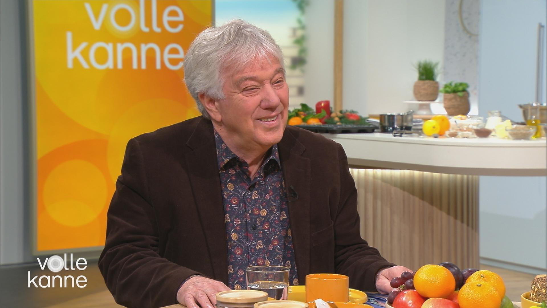 Musiker Rolf Zuckowski sitzt bei Volle Kanne im Studio am Frühstückstisch.