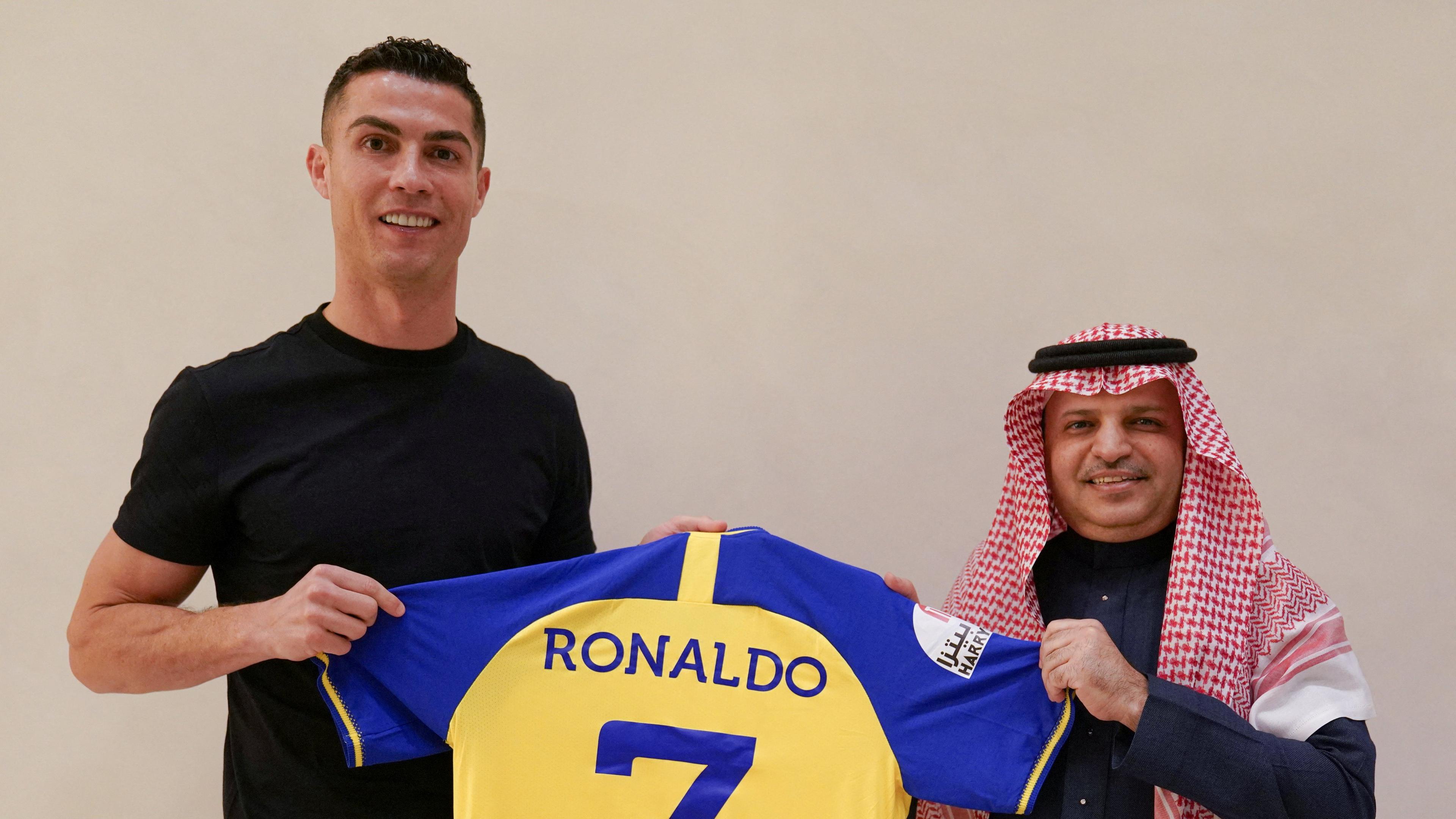 Fußballspieler Cristiano Ronaldo zusammen mit Musalli Al-Muamma. Er hält sein neues Trikot in der Hand. 