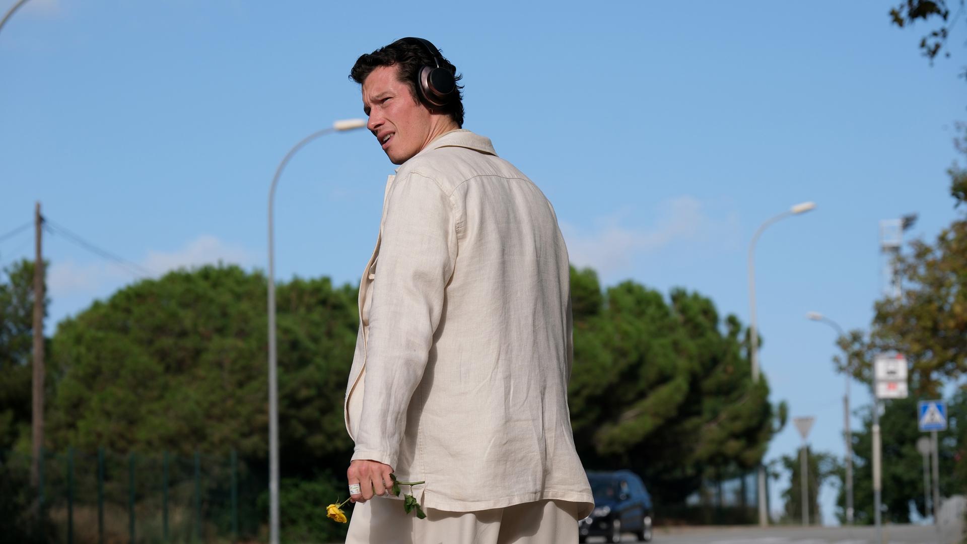 Junger Mann auf Straße schaut sich um.