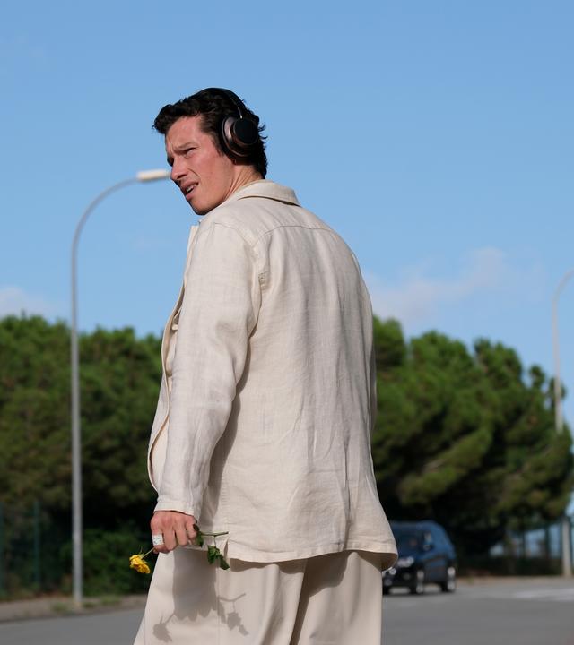 Junger Mann auf Straße schaut sich um.