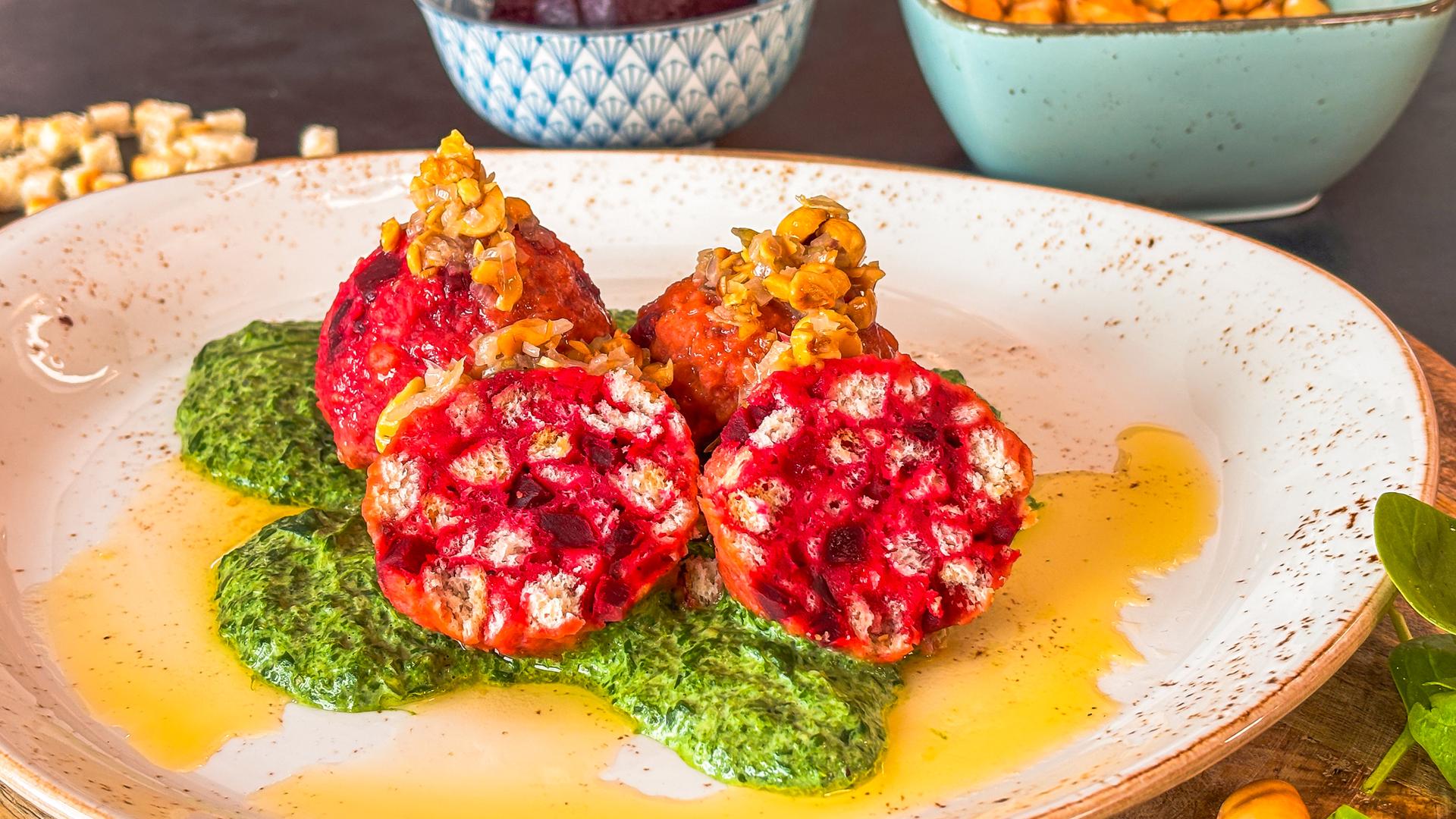 Rote-Bete-Knödel mit Rahmspinat auf einem Teller serviert.
