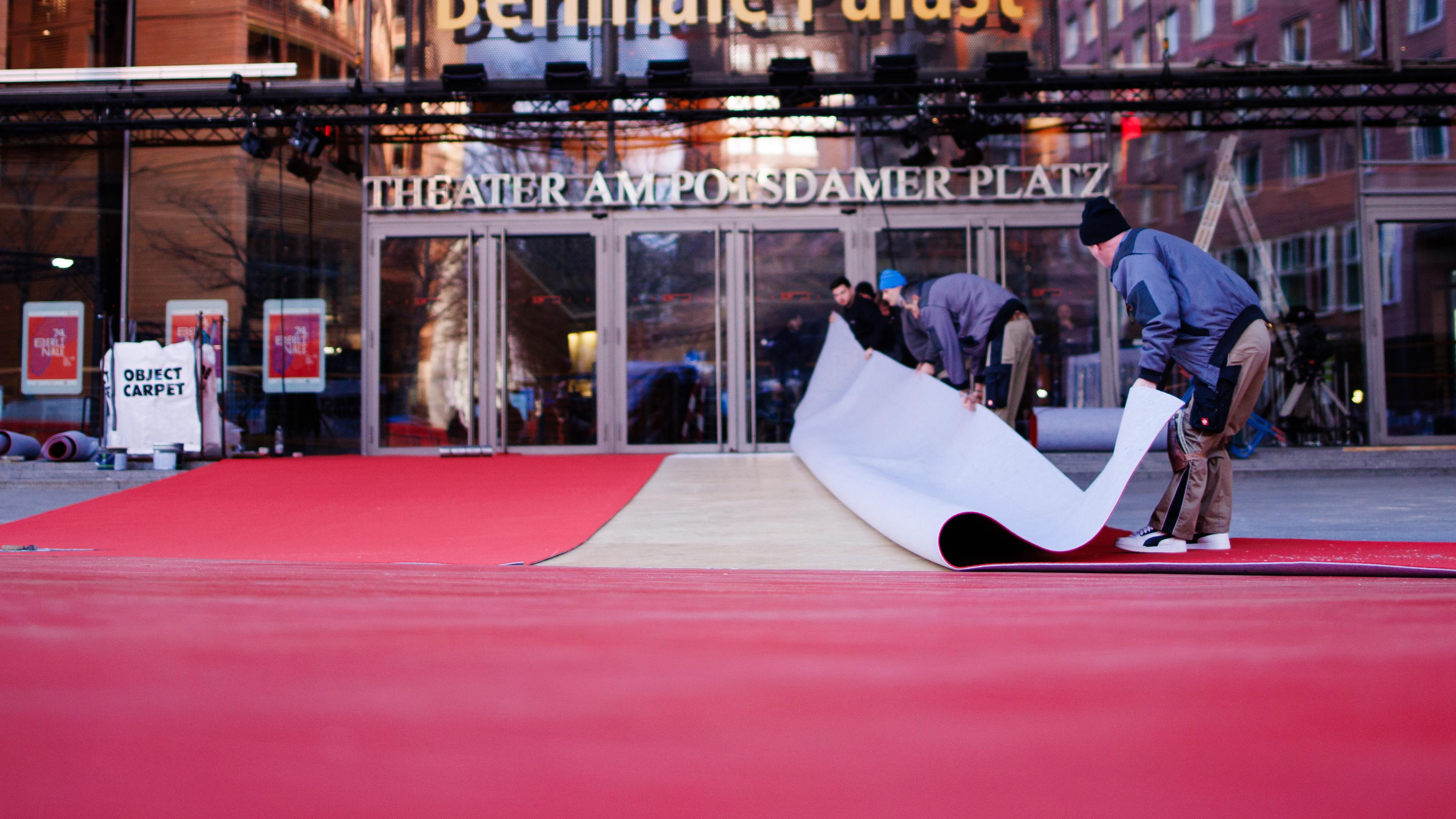 Arbeiter verlegen roten Teppich vor dem Eingang des Berlinale Palastes.