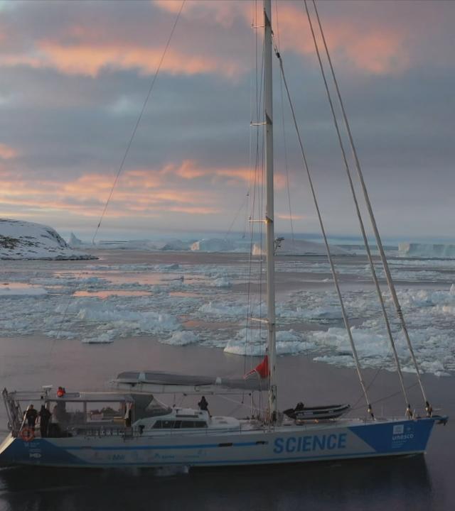 Ein Segelschiff in der Antarktis vor rosa Wolken