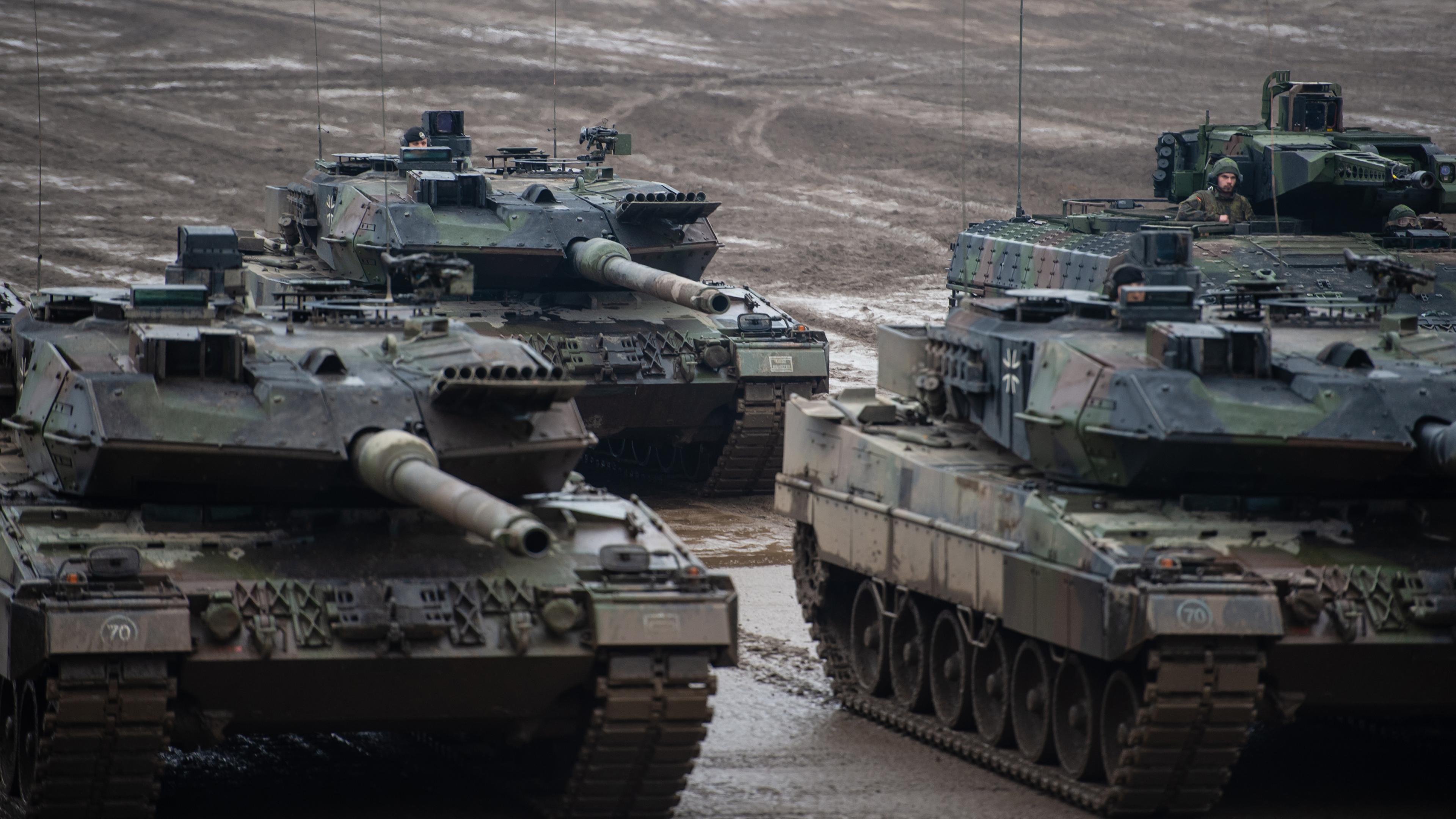 Munster: Drei Kampfpanzer der Bundeswehr vom Typ Leopard 2A6 und ein Schützenpanzer vom Typ Puma stehen bei einer Übung im Gelände. Archivbild