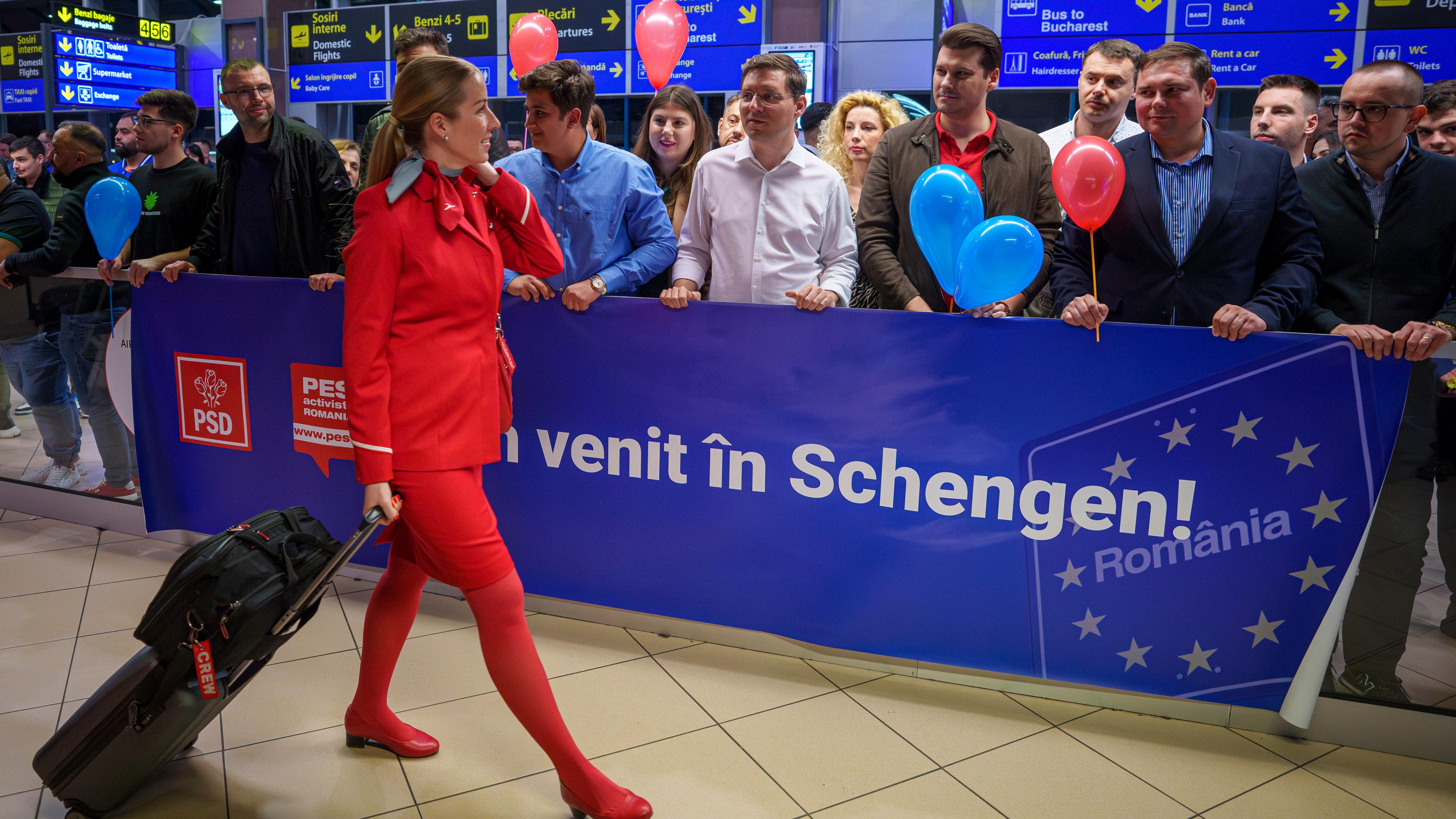 Eine Flugbegleiterin geht an einem Schild mit der Aufschrift "Willkommen in Schengen" vorbei, als sie auf dem internationalen Flughafen Henri Coanda in Otopeni in der Nähe von Bukarest ankommt.