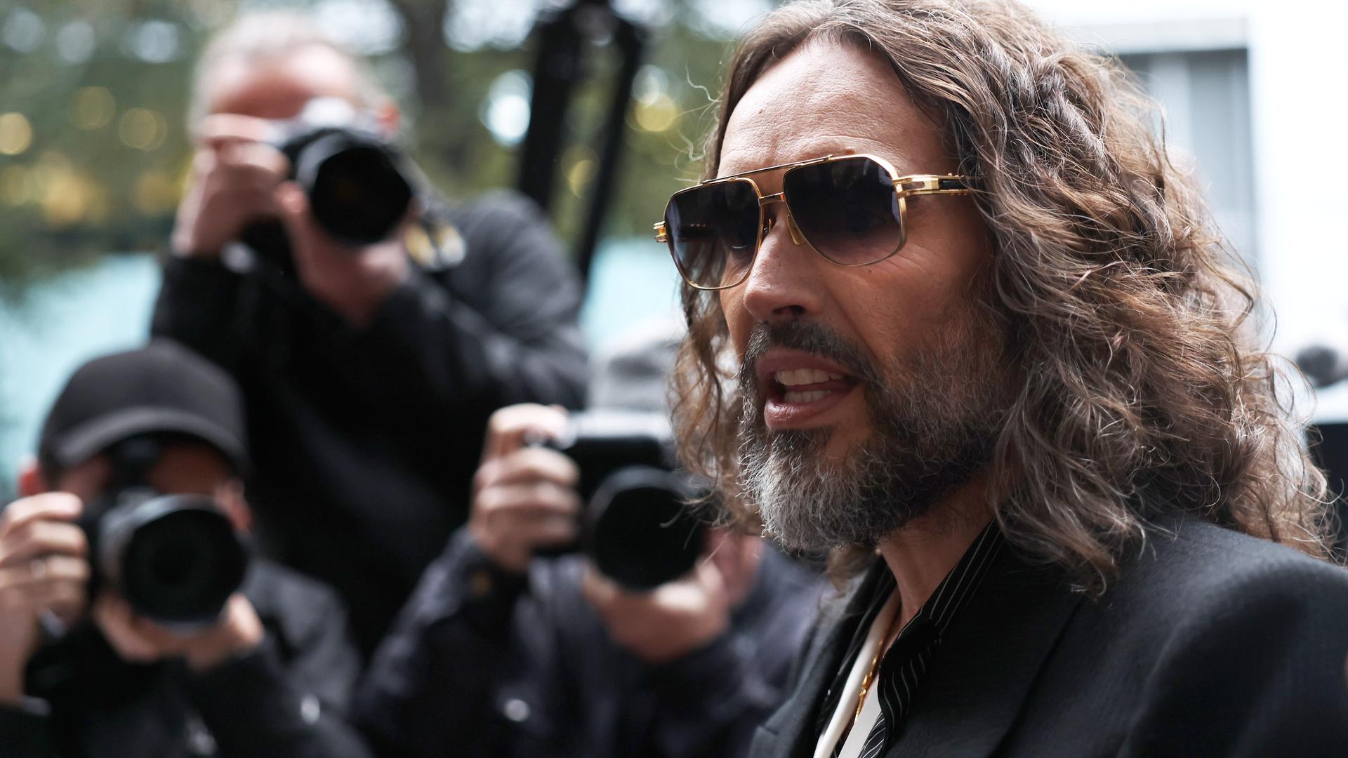 Russell Brand auf dem Weg in das Gericht in London . Fotografen warten auf ihn. 