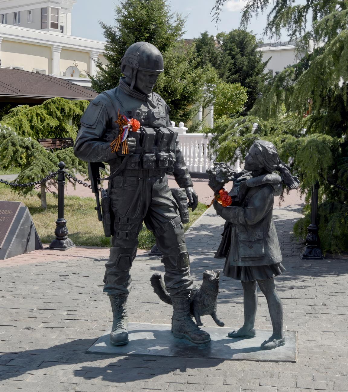 Ein Mädchen reicht einem Soldaten eine Blume. Beide Personen im Denkmal werden als Statuen dargestellt.