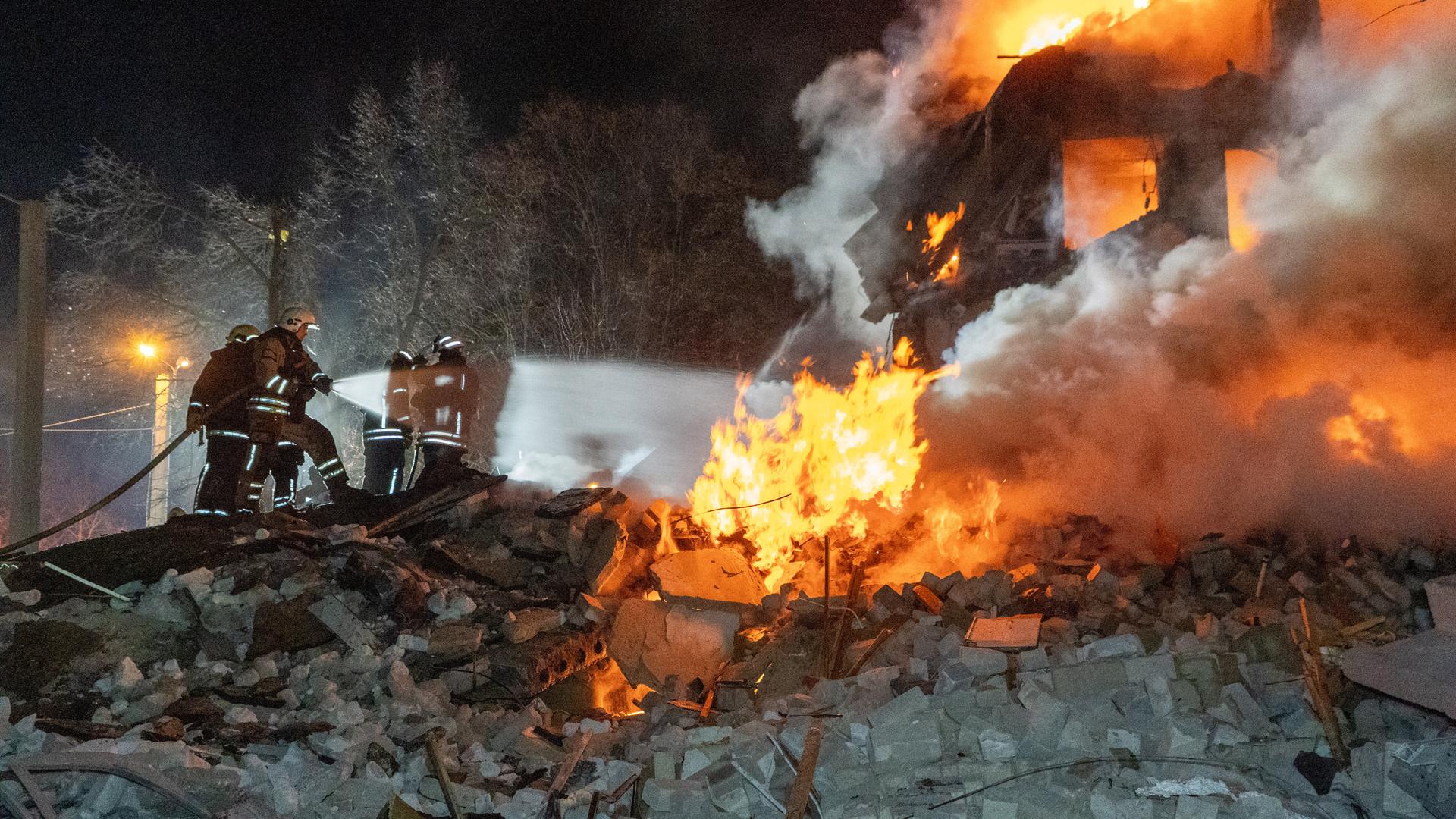 07.03.2026, Ukraine, Charkiw: Feuerwehrleute löschen das Feuer in einem mehrstöckigen Wohnhaus nach einem russischen Raketenangriff in Charkiw, Ukraine.