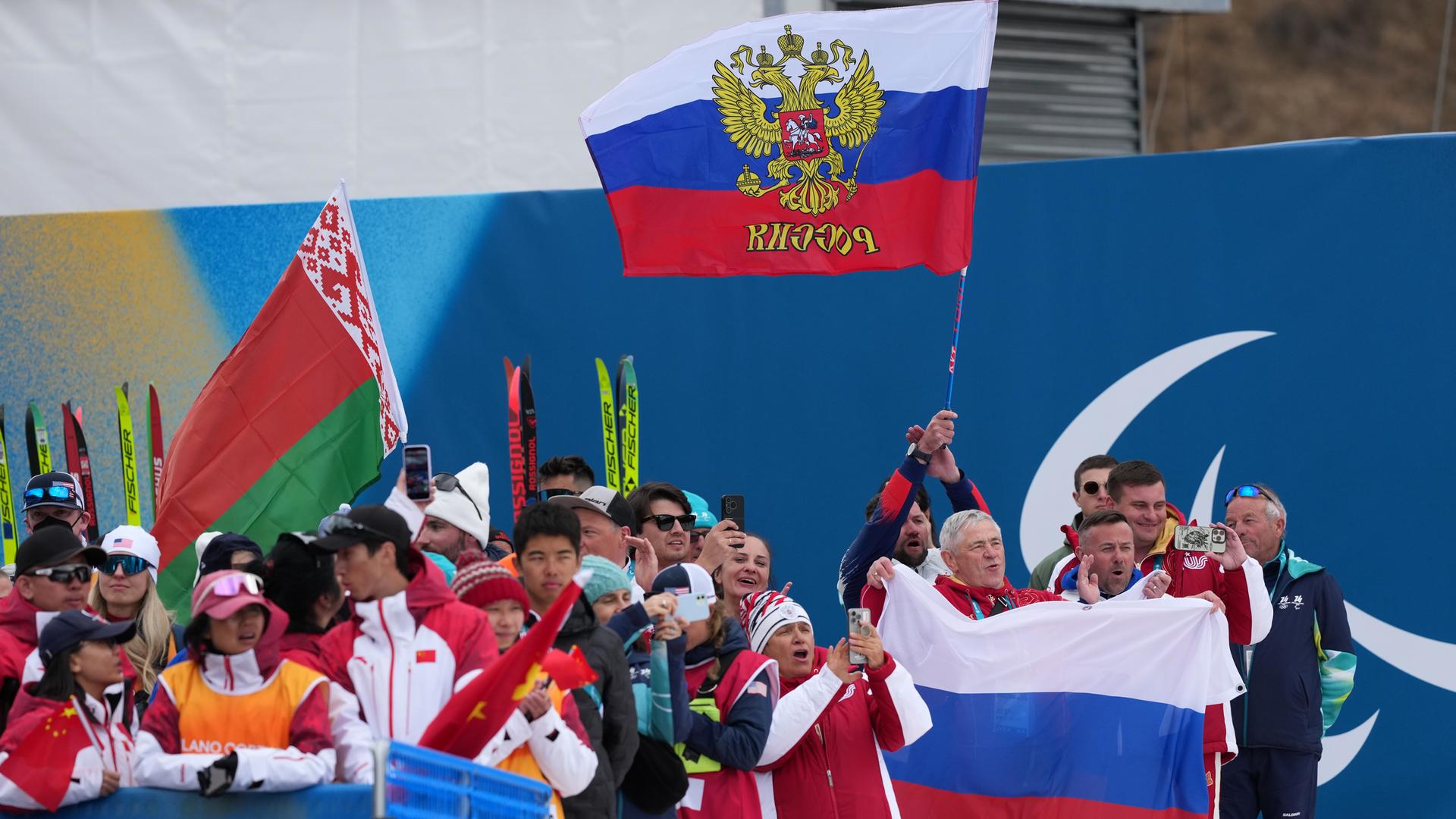 Zuschauer schwenken eine belarussische und zwei russischen Fahnen.