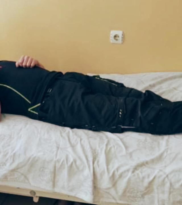 Verletzter liegt mit Kopfverband auf einem Krankenhausbett 