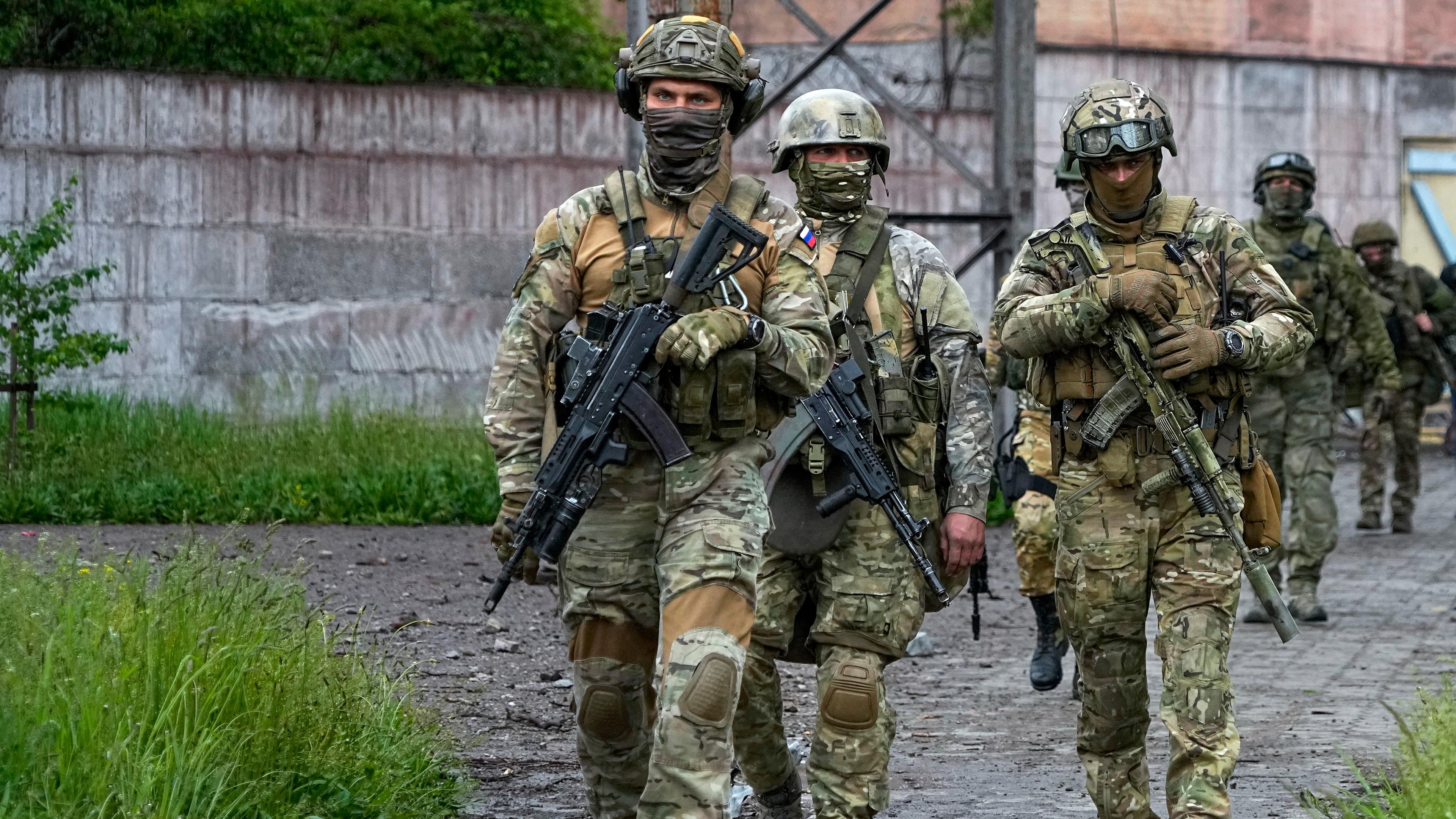Russische Soldaten gehen durch einen zerstörten Bereich des Iljitsch Eisen- und Stahlwerks Mariupol in Mariupol (Ukraine), aufgenommen am 18.05.2022