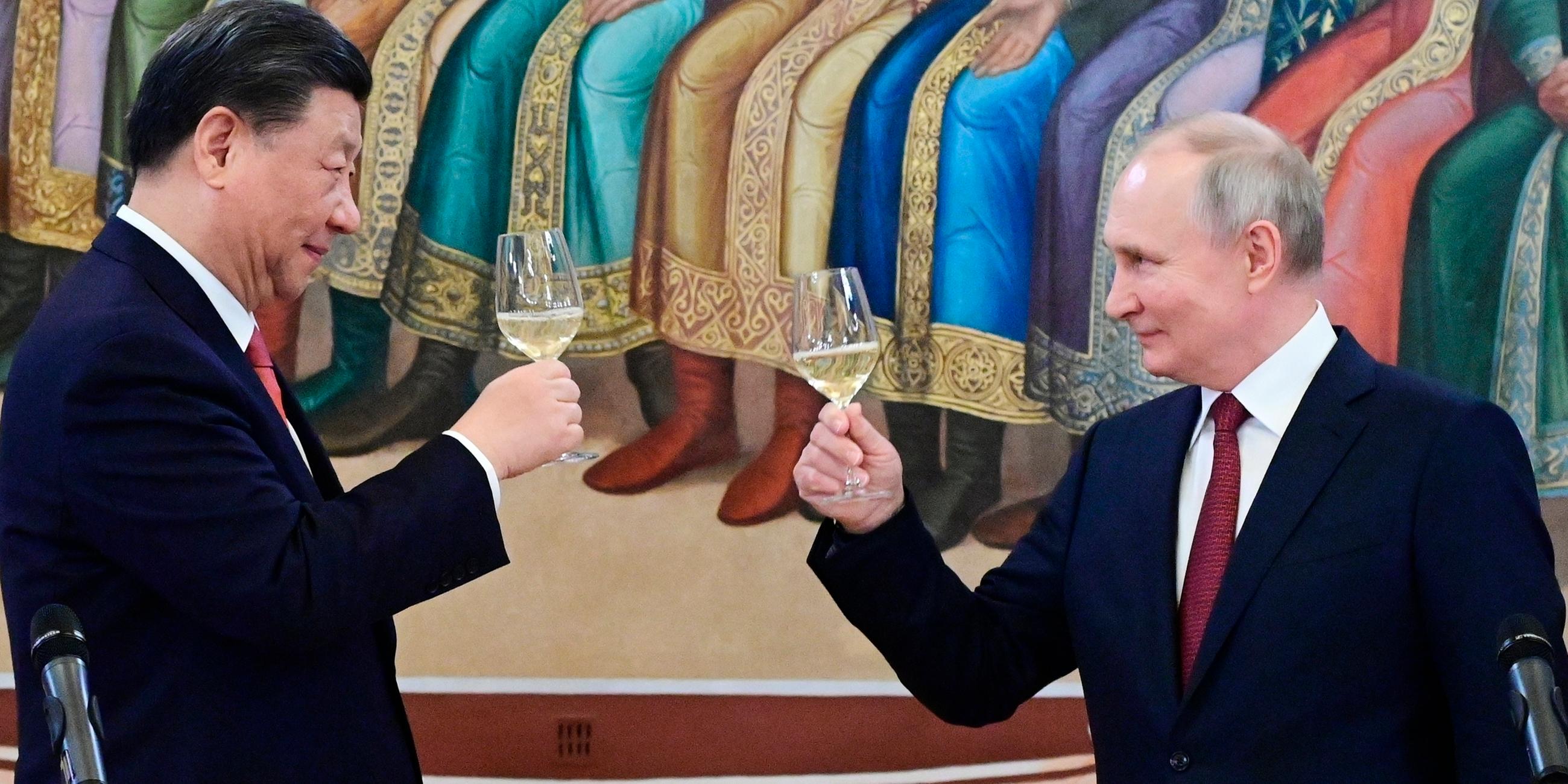 Links im Bild Chinas Staatschef Xi Jinping, rechts der russische Präsident Wladimir Putin. Sie stoßen mit Weingläsern an.