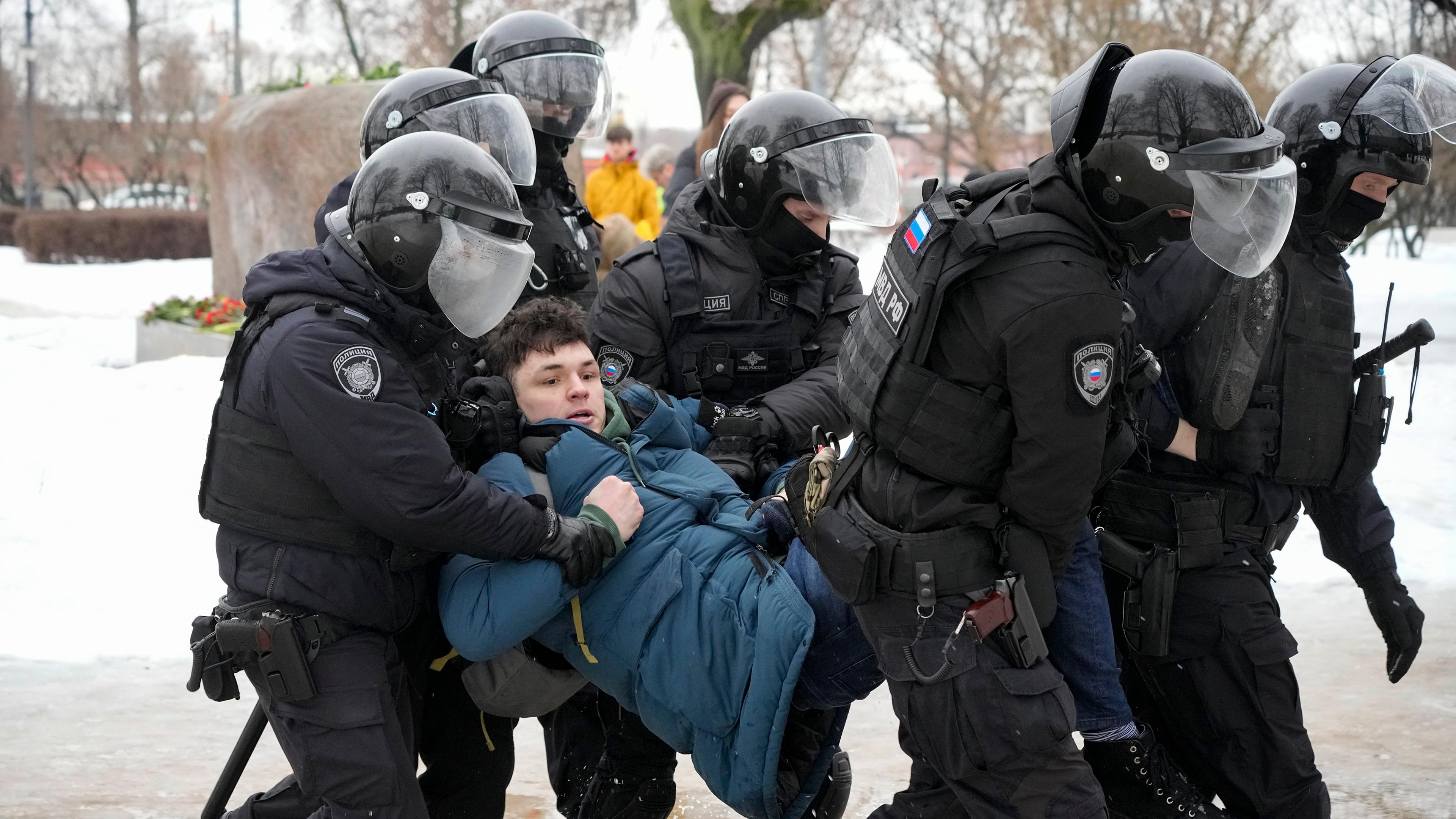 Ein Mann, welcher nach dem Tod von Alexej Nawalny Blumen niederlegen wollte, wird von Polizisten festgenommen.