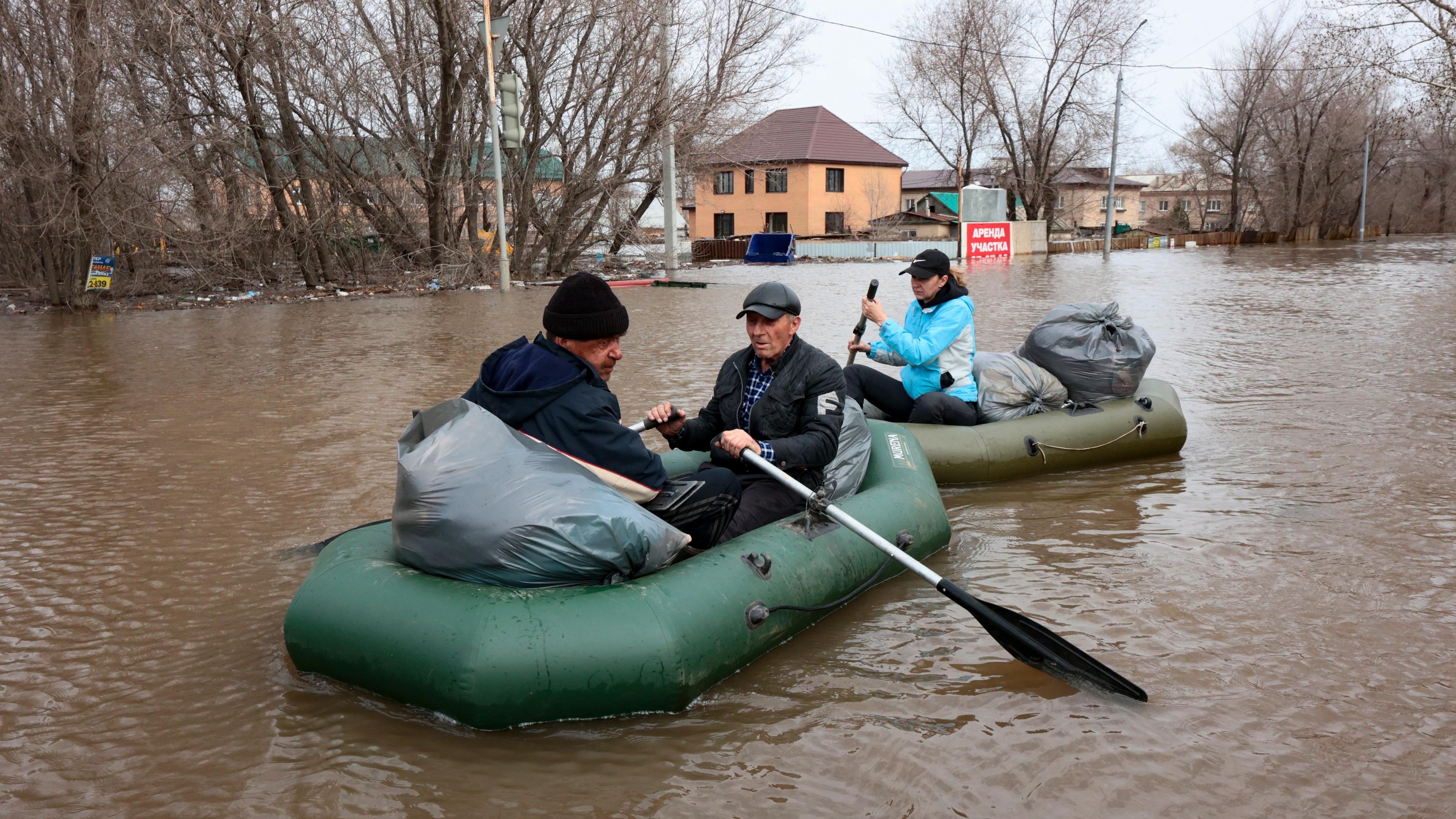 Russland, Orenburg: Anwohner rudern Boote auf der überfluteten Straße.