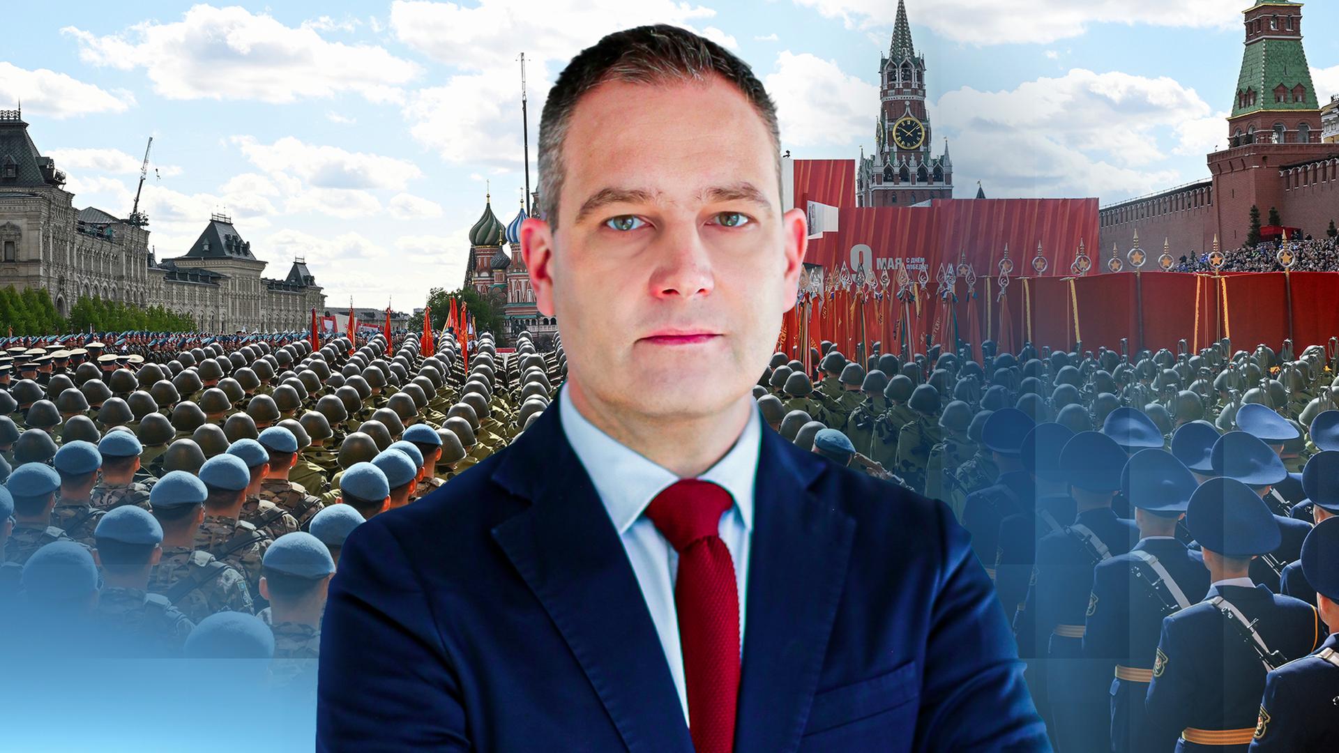 Militärexperte Gustav Gressel steht vor einem Ausschnitt der russischen Militärparade zum 9. Mai. 
