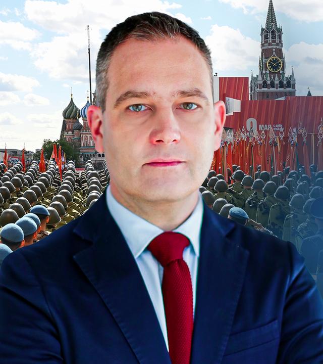 Militärexperte Gustav Gressel steht vor einem Ausschnitt der russischen Militärparade zum 9. Mai. 