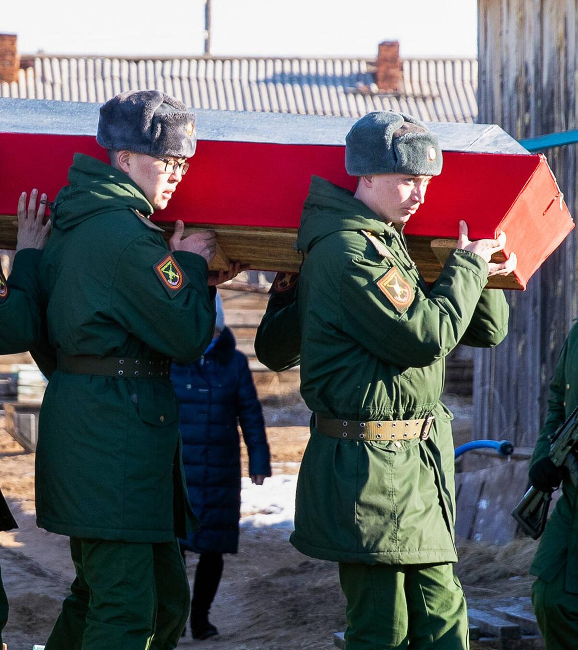 Russische Soldaten tragen einen Sarg