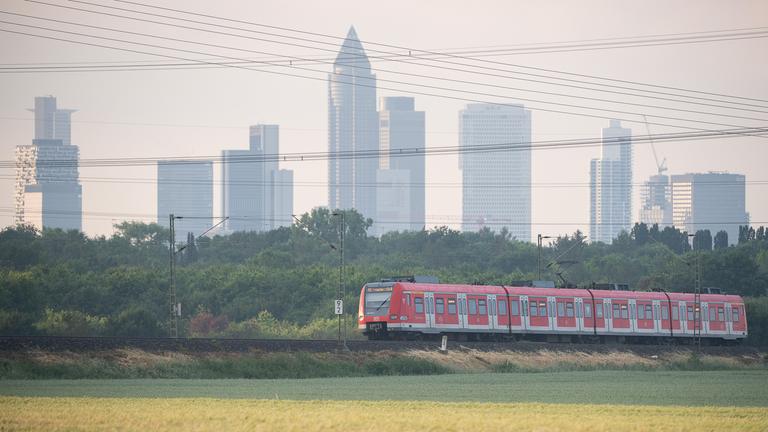 Eine S-Bahn fährt vor der Frankfurter Skyline.
