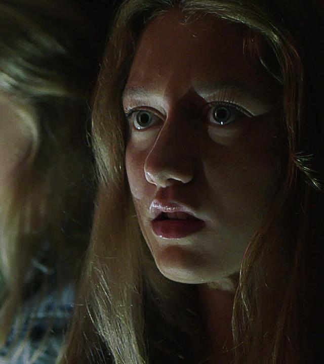 Im Dunkeln sitzen Victoria, Mina und Tara mit ernsten Gesichtern, die mehr oder weniger von Licht angeleuchtet sind.