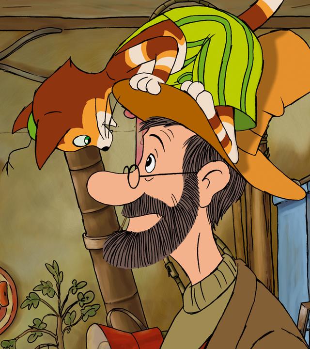 Pettersson steht in seiner Werkstatt. Findus turnt auf seinem Hut herum und blickt ihn über den Hutrand kopfüber an.