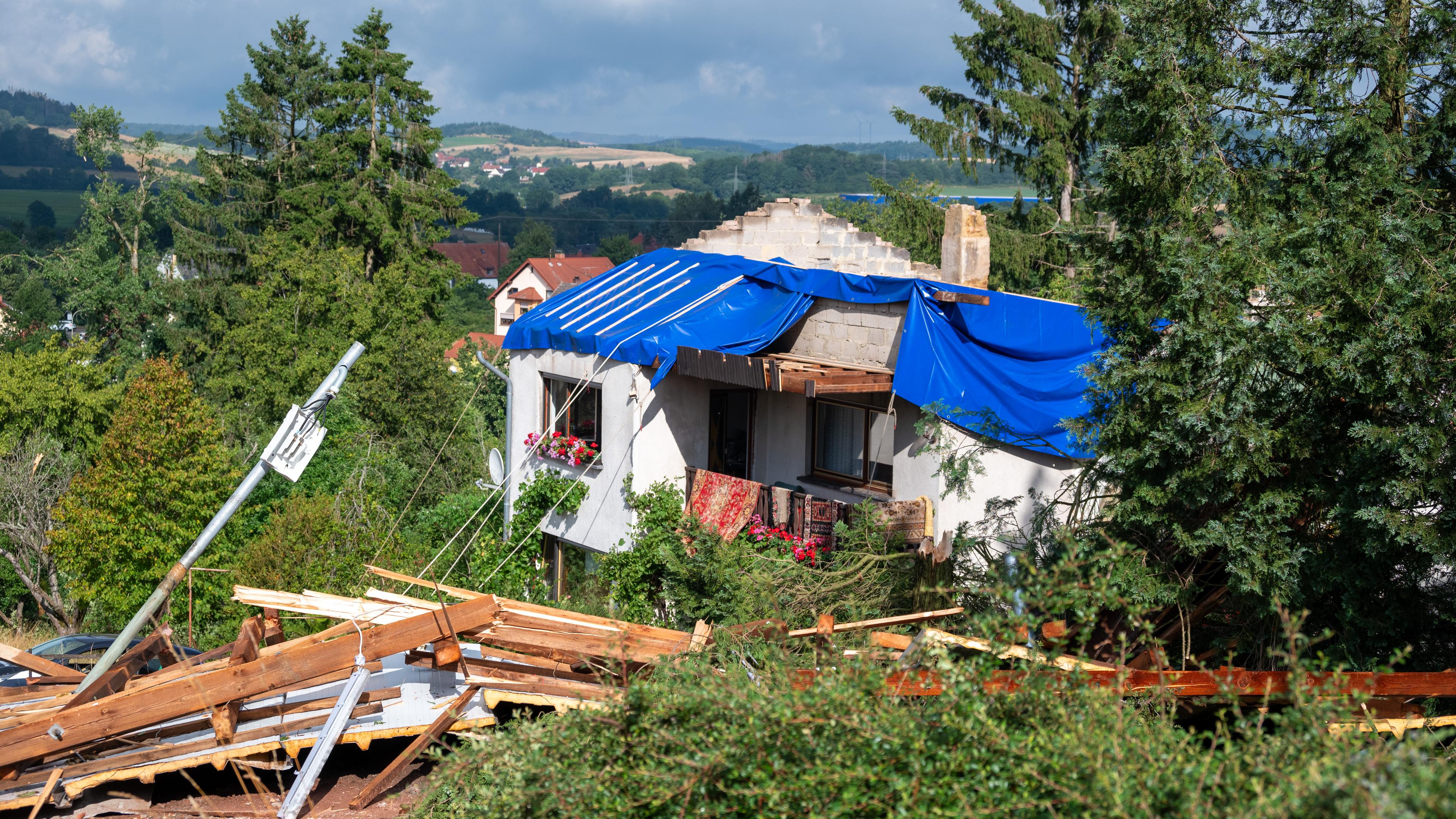 Saarland, Asweiler: Ein schwer beschädigtes Haus, dessen Dach von einem Sturm abgedeckt wurde, ist mit Planen abgedeckt. In Asweiler in der Gemeinde Freisen (Landkreis St. Wendel) 
