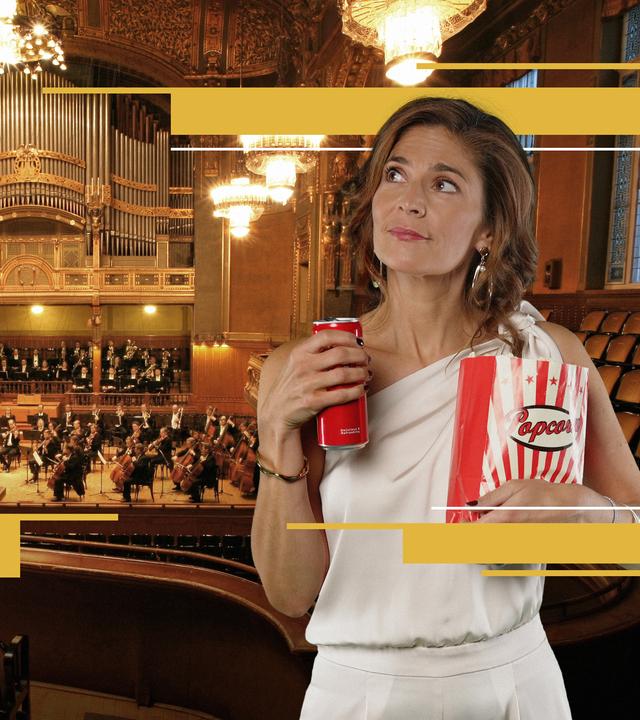 Katty Salié mit geniesserischen Blick mit Getränkedose und Popcorntüte in einem opulenten Konzertsaal.