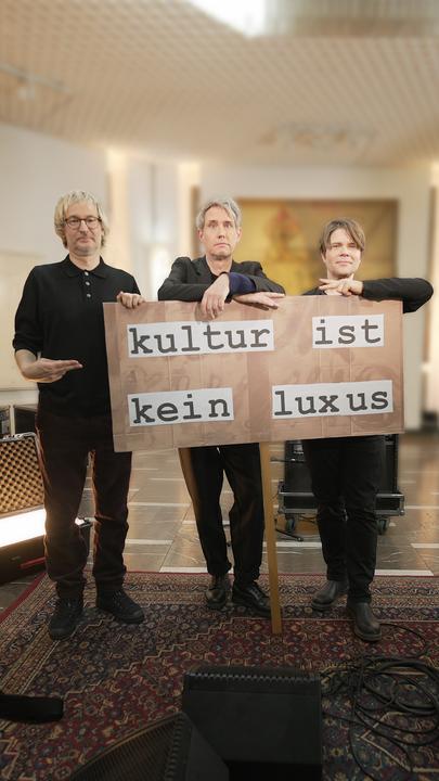 Moderatorin Katty Salié und die Band Tocotronic mit Demoposter "Kultur ist kein Luxus"