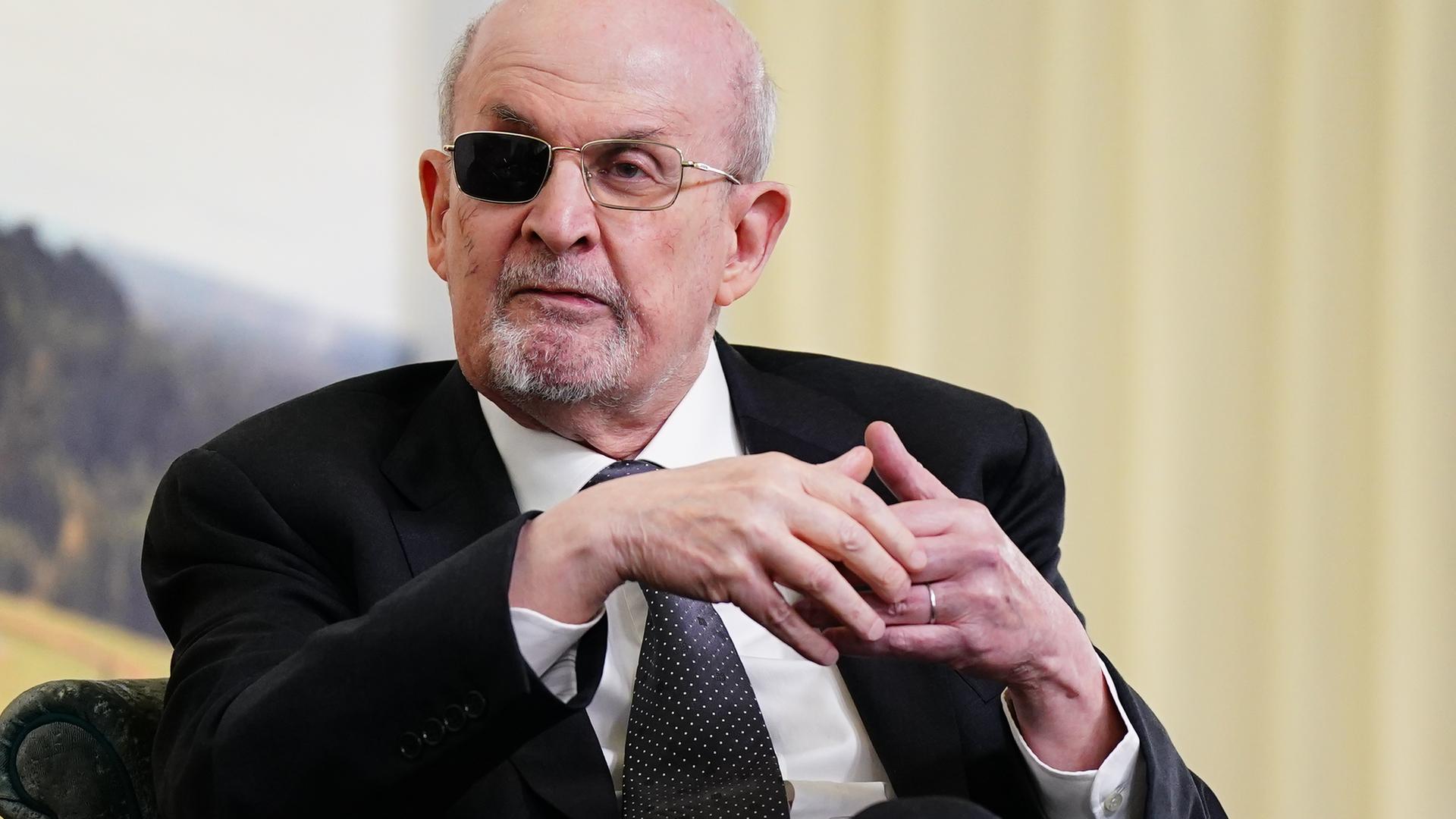 Ein älterer Mann mit graumeliertem Bart und einem geschwärzten Brillenglas.