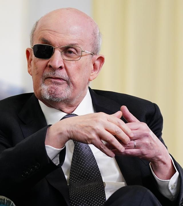 Ein älterer Mann mit graumeliertem Bart und einem geschwärzten Brillenglas.