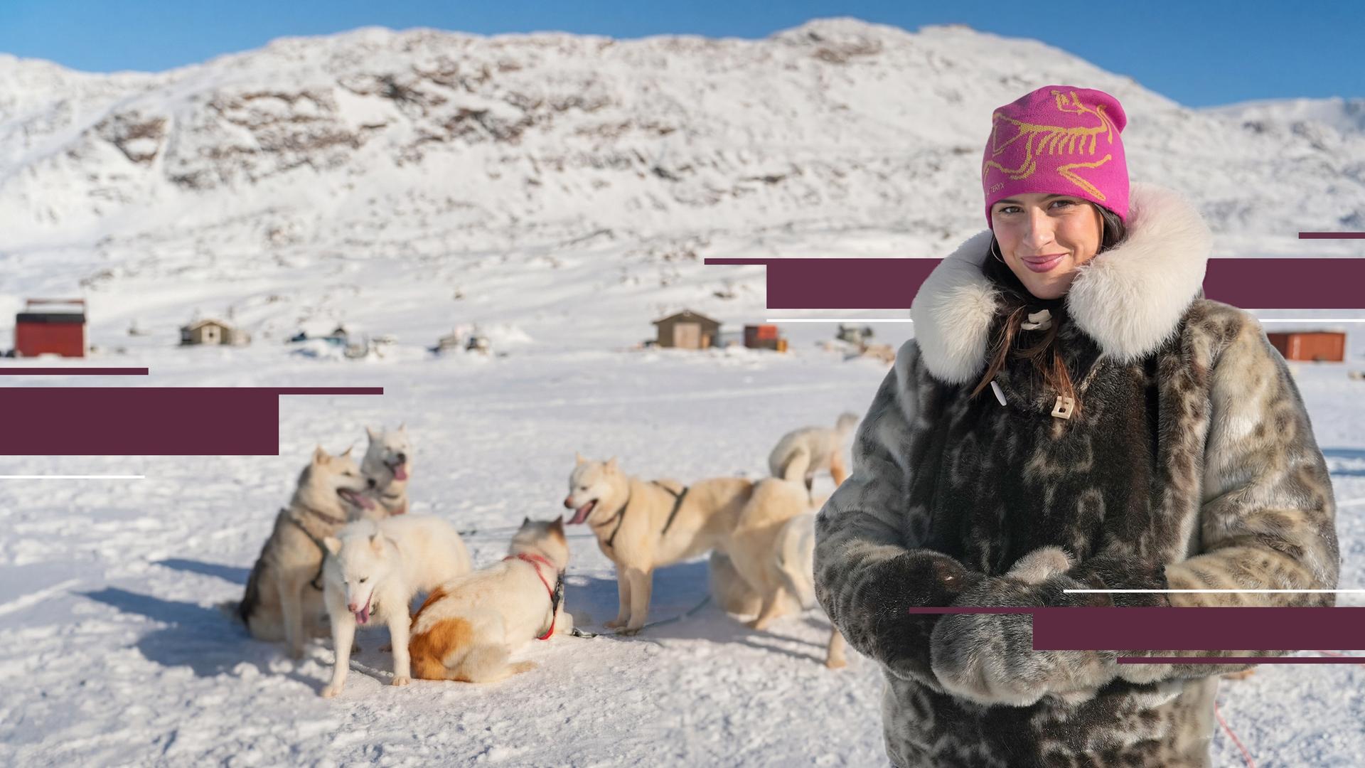 Salwa Houmsi in Sisimiut, der zweitgrößten Stadt Grönlands. Sie steht in einer Schneelandschaft, hinter ihr sind Schlittenhunde zu sehen.