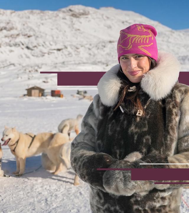 Salwa Houmsi in Sisimiut, der zweitgrößten Stadt Grönlands. Sie steht in einer Schneelandschaft, hinter ihr sind Schlittenhunde zu sehen.