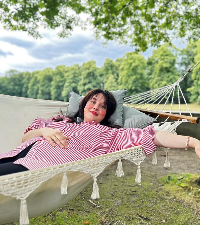 Junge Frau liegt inn der Hängematte