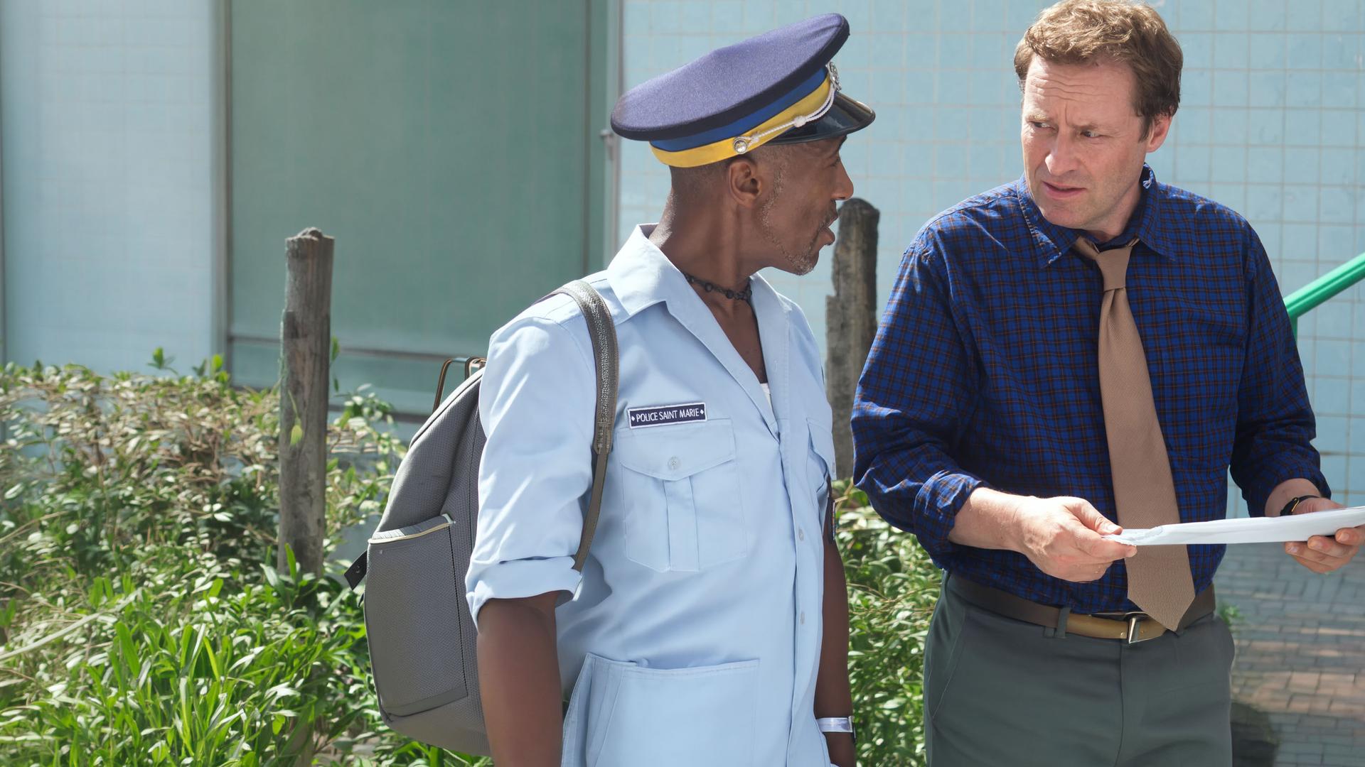 "Death in Paradise - Sankta Ursula": Großaufnahme DI Jack Mooney (Ardal O''Hanlon) und Dwayne (Danny John-Jules) unterhalten sich.