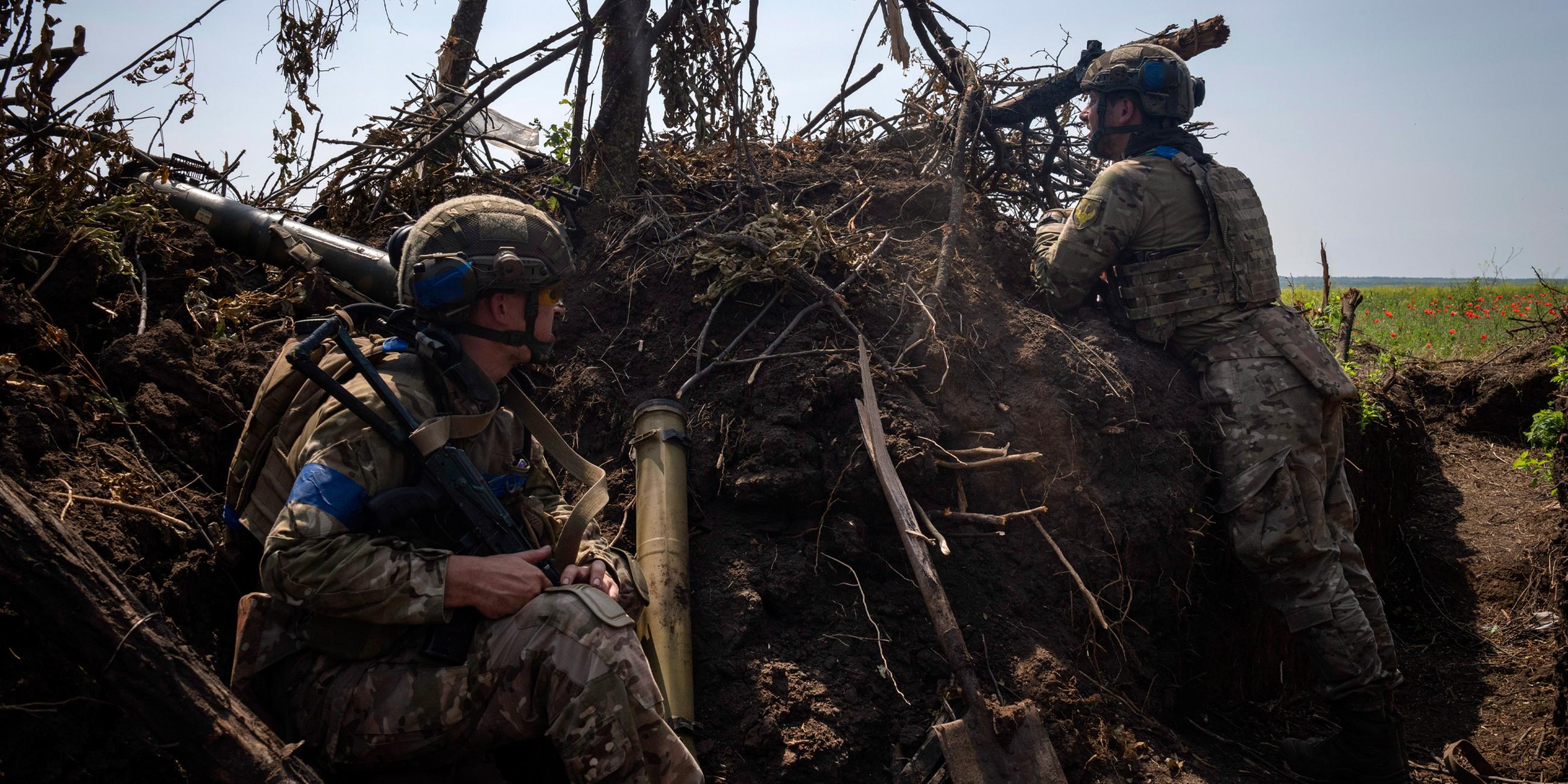 Archiv: Ukrainische Soldaten schauen aus einem Schützengraben an der Frontlinie in der Region Saporischschja heraus. (23.06.2023)