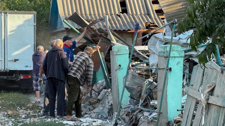 Menschen räumen Trümmer an der Einschlagstelle eines russischen Angriffs auf ein Gebäude in Saporischschja, Ukraine, am 12. September 2026, inmitten der anhaltenden russischen Invasion.
