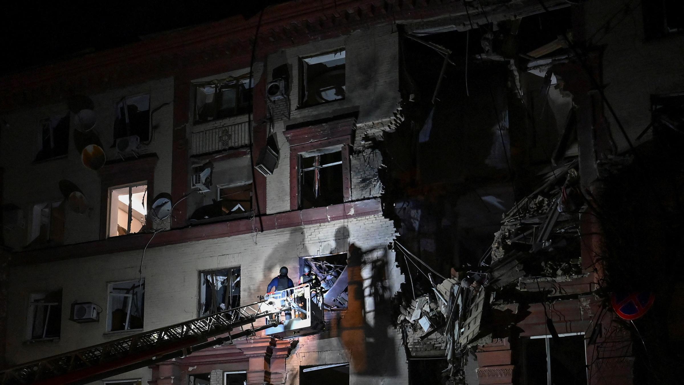 Rettungskräfte arbeiten Raketeneinschlag an einem Wohnhaus in Saporischschja