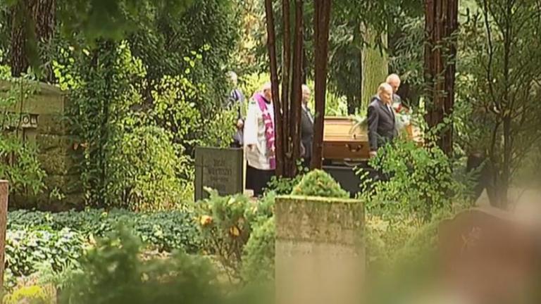 Sarg wird auf dem Friedhof zu Grabe getragen