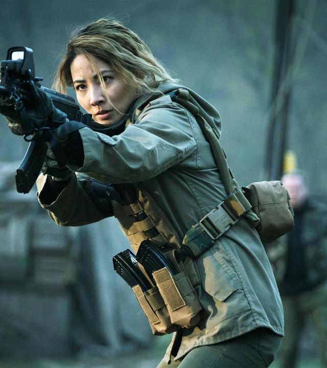 Zada (Jing Lusi) läuft angespannt mit einem Gewehr.
