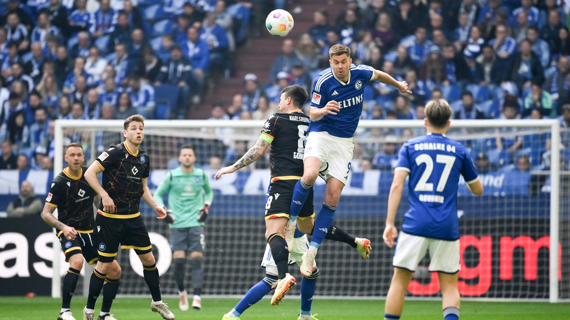 Schalkes Simon Terodde und Karlsruhes Jerome Gondorf im Kampf um den Ball am 31.03.2024.