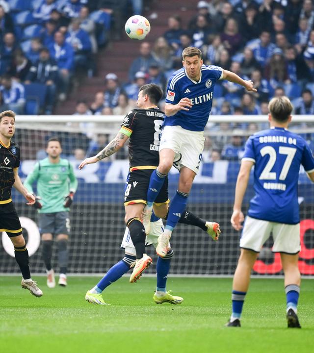 Schalkes Simon Terodde und Karlsruhes Jerome Gondorf im Kampf um den Ball am 31.03.2024.