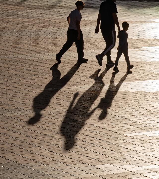 Menschen laufen durch die Stadt und werfen Schatten