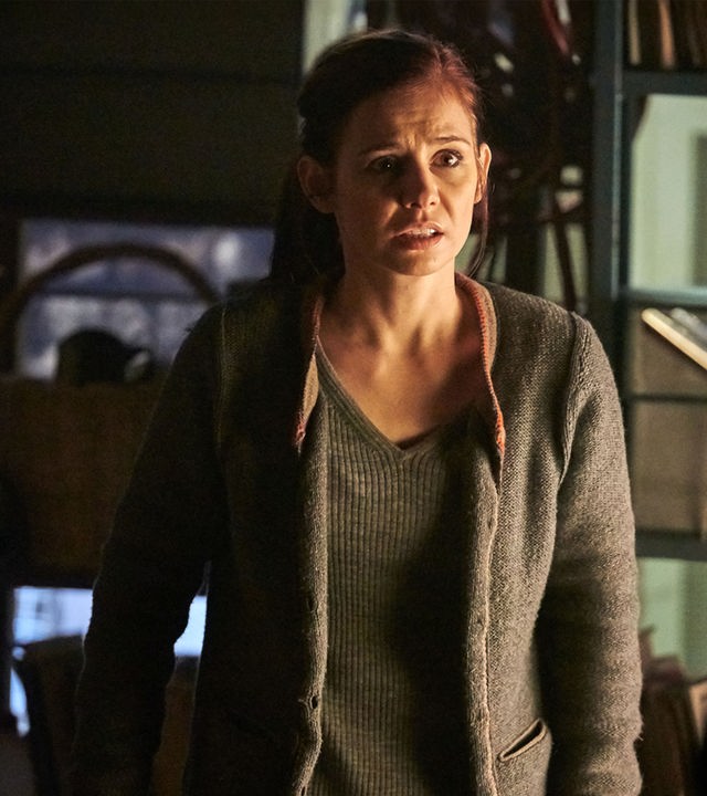 "Schattengrund": Nicola Wagner (Josefine Preuß) steht im Keller und sieht verängstigt zu der Frau, die vor ihr steht. Diese ist nur unscharf von hinten zu sehen, wie sie eine Waffe auf Nicola richtet.